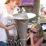 League member with young girl playing tuba