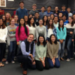 High school students standing with New West Symphony conductor