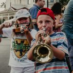 Young children playing trumpet and violin at festival