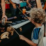 Small boy playing xylophone and other percussion instruments